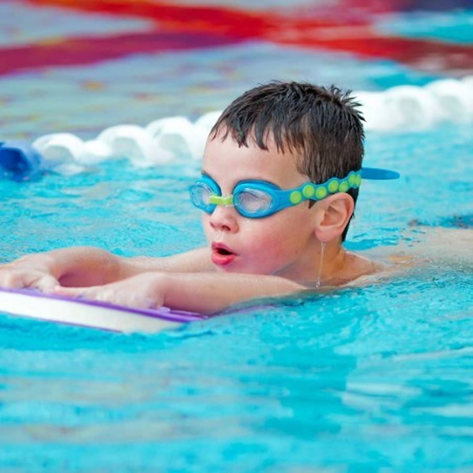 A child learning to swim during a swimming lesson in The Warwickshire's swimming pool