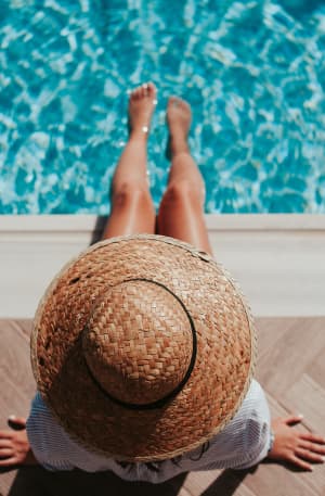 Person enjoying the sunshine by a swimming pool
